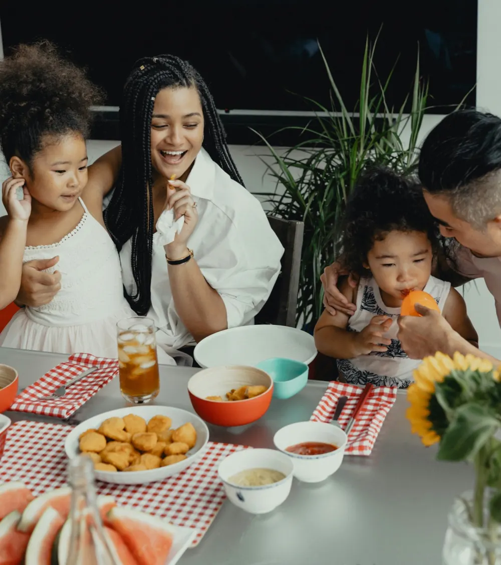 A joyful multiracial family sharing a meal together around the dinner table
